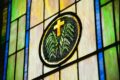 Colorful stained glass window featuring a cross and palm branches, perfect for religious themes.